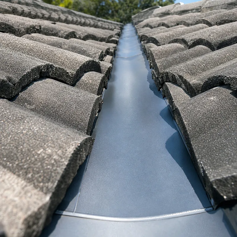 Close-up of repaired valley flashing and properly aligned concrete roof tiles